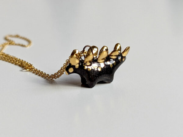 shiny black stegosaurus pendant with gold