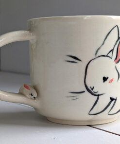 adorable white mug with bunnies and a sculpted handle with a tiny bun