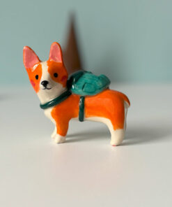 adorable corgi figurine in a backpack