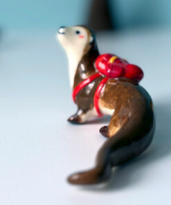 adorable porcelain otter figurine with a backpack