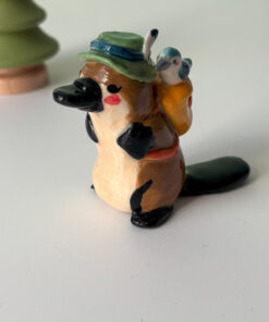 adorable platypus figurine with a backpack and feathered hat