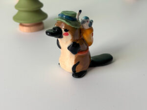 adorable platypus figurine with a backpack and feathered hat