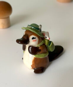 adorable platypus figurine with a backpack and feathered hat