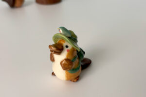 adorable platypus figurine with a backpack and feathered hat