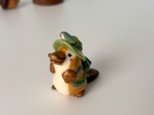 adorable platypus figurine with a backpack and feathered hat