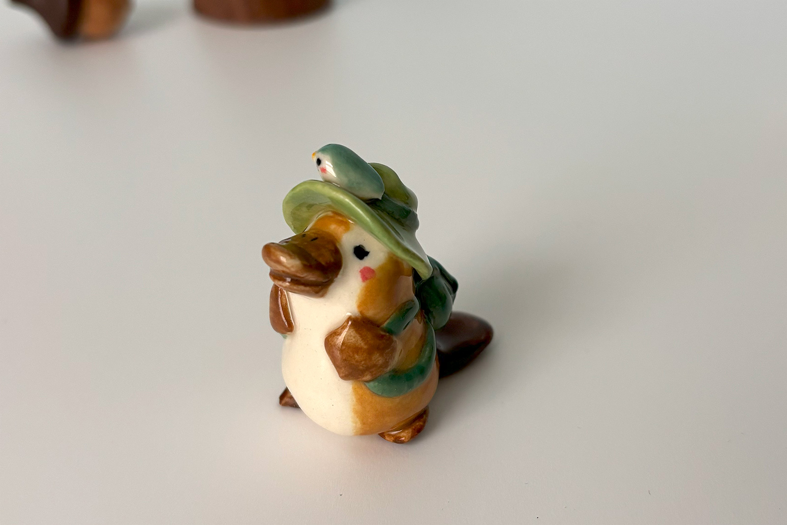 adorable platypus figurine with a backpack and feathered hat
