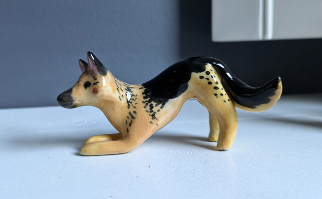 figurine dog portrait of a german shepherd in a play bow